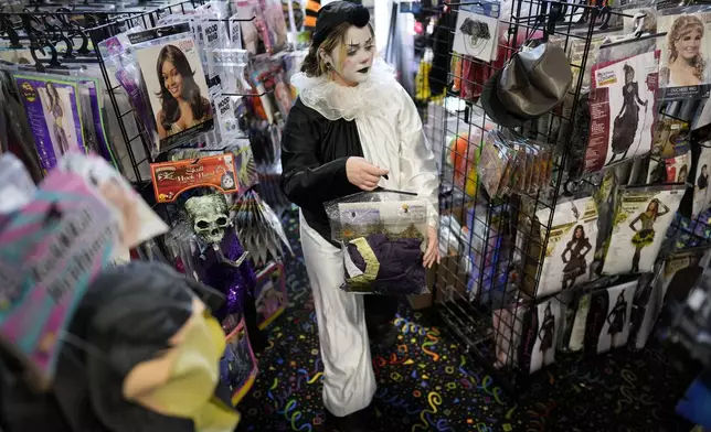 Olive Luther stocks costume displays at The Theatrical Shop, Tuesday, Oct. 29, 2024, in West Des Moines, Iowa. (AP Photo/Charlie Neibergall)