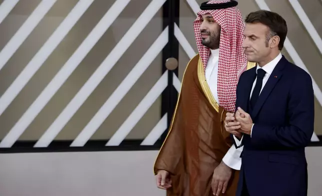 French President Emmanuel Macron, right, speaks with Saudi Arabia's Prime Minister and Crown Prince Mohammed bin Salman bin Abdulaziz Al Saud prior to a group photo at an EU-Gulf Cooperation Council meeting in Brussels, Belgium, Wednesday, Oct. 16, 2024. (AP Photo/Omar Havana)