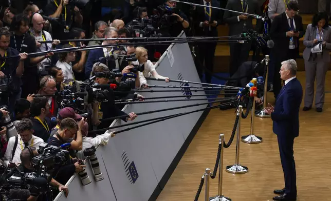 Lithuania's President Gitanas Nauseda talks to journalists as he arrives to an EU summit in Brussels, Thursday, Oct. 17, 2024. (AP Photo/Omar Havana)