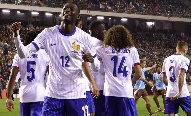 France's Randal Kolo Muani, left, celebrates after scoring his sides second goal during the UEFA Nations League, group A2 soccer match between Belgium and France at the King Baudouin stadium in Brussels, Belgium, Monday, Oct. 14, 2024. (AP Photo/Geert Vanden Wijngaert)