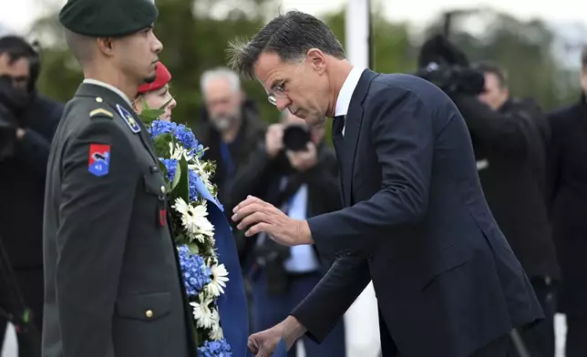 The incoming NATO Secretary General Mark Rutte lays a wreath during a transition ceremony at NATO headquarters in Brussels, Belgium, Tuesday, Oct. 1, 2024. (AP Photo/Harry Nakos)