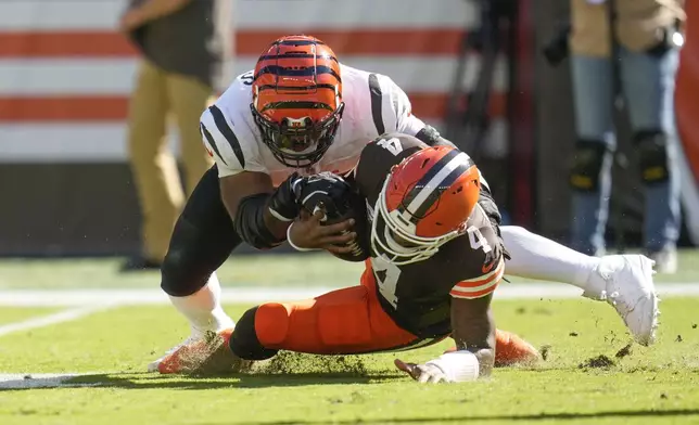 Cleveland Browns quarterback Deshaun Watson (4) is tackled by Cincinnati Bengals defensive tackle Sheldon Rankins in the first half of an NFL football game, Sunday, Oct. 20, 2024, in Cleveland. (AP Photo/Sue Ogrocki)