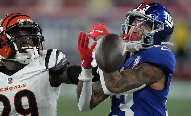 New York Giants wide receiver Jalin Hyatt (13) is unable to make the catch as Cincinnati Bengals cornerback Cam Taylor-Britt (29) defends during the second half of an NFL football game, Sunday, Oct. 13, 2024, in East Rutherford, N.J. (AP Photo/Seth Wenig)