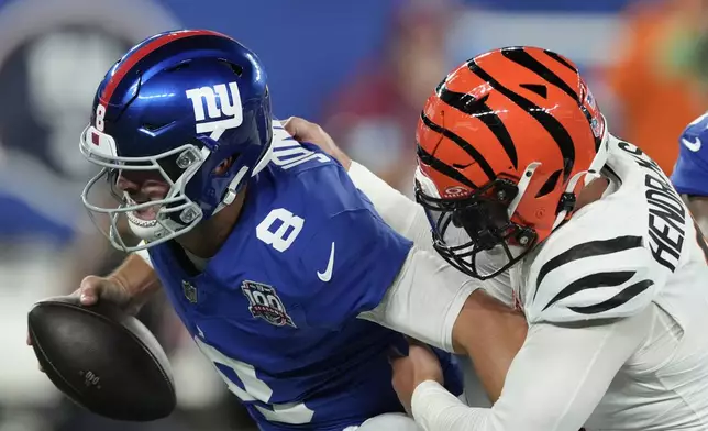 New York Giants quarterback Daniel Jones (8) is sacked by Cincinnati Bengals defensive end Trey Hendrickson (91) during the first half of an NFL football game, Sunday, Oct. 13, 2024, in East Rutherford, N.J. (AP Photo/Seth Wenig)