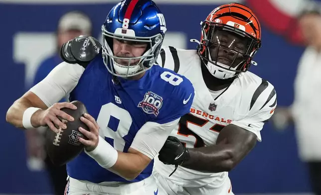 New York Giants quarterback Daniel Jones (8) escapes from Cincinnati Bengals defensive end Isaiah Thomas (51) during the first half of an NFL football game, Sunday, Oct. 13, 2024, in East Rutherford, N.J. (AP Photo/Seth Wenig)