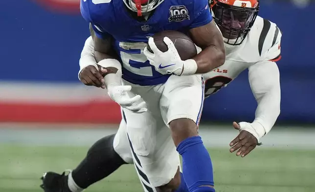 New York Giants cornerback Cor'Dale Flott (28) runs past Cincinnati Bengals defensive end Joseph Ossai (58) during the second half of an NFL football game, Sunday, Oct. 13, 2024, in East Rutherford, N.J. (AP Photo/Frank Franklin II)