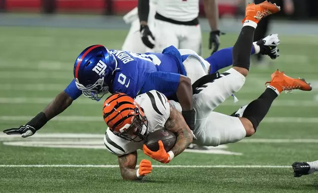 New York Giants linebacker Brian Burns (0) tackles Cincinnati Bengals running back Chase Brown during the second half of an NFL football game, Sunday, Oct. 13, 2024, in East Rutherford, N.J. (AP Photo/Frank Franklin II)