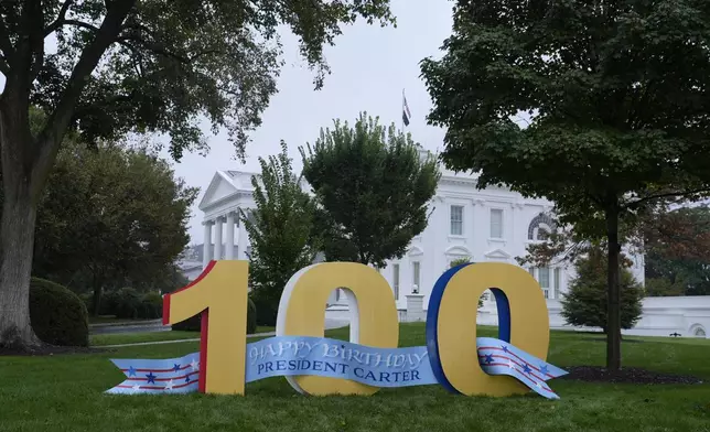 A sign wishing former President Jimmy Carter a happy 100th birthday sits on the North Lawn of the White House in Washington, Tuesday, Oct. 1, 2024. (AP Photo/Susan Walsh)