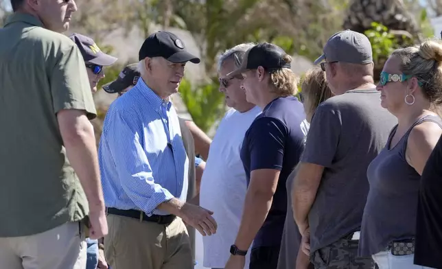 President Joe Biden, second left, meets with residents and federal, state, and local officials in St. Pete Beach, Fla., during a tour of areas affected by Hurricane Milton, Sunday, Oct. 13, 2024. (AP Photo/Manuel Balce Ceneta)