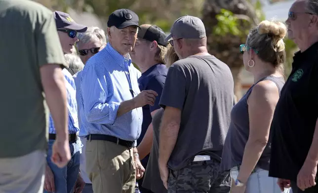 President Joe Biden, second left, joined by Sen. Rick Scott, R-Fla., left, speaks with residents and federal, state, and local officials in St. Pete Beach, Fla., during a tour of areas affected by Hurricane Milton, Sunday, Oct. 13, 2024. (AP Photo/Manuel Balce Ceneta)