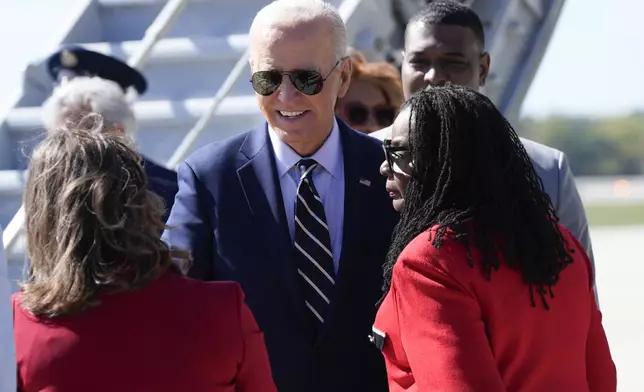 President Joe Biden is greeted by Rep. Gwen Moore, D-Wis., right, and other officials after arriving at Milwaukee Mitchell International Airport in Milwaukee, Tuesday, Oct. 8, 2024. (AP Photo/Susan Walsh)