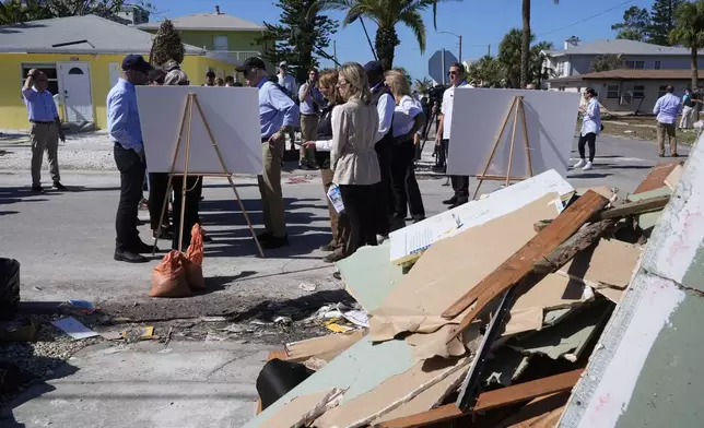 President Joe Biden, second left, is briefed by federal, state, and local officials in St. Pete Beach, Fla., following an aerial tour of the Hurricane Milton affected areas, Sunday, Oct. 13, 2024. (AP Photo/Manuel Balce Ceneta)