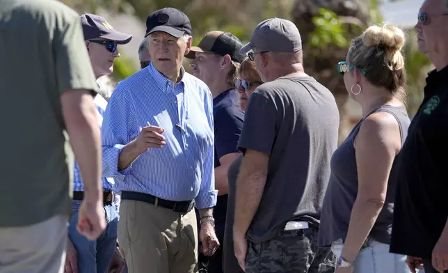 President Joe Biden, second left, meets with residents and federal, state, and local officials in St. Pete Beach, Fla., during a tour of areas affected by Hurricane Milton, Sunday, Oct. 13, 2024. (AP Photo/Manuel Balce Ceneta)