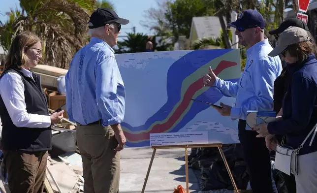 President Joe Biden, second left, is briefed by federal, state, and local officials in St. Pete Beach, Fla., following an aerial tour of the Hurricane Milton affected areas, Sunday, Oct. 13, 2024. (AP Photo/Manuel Balce Ceneta)