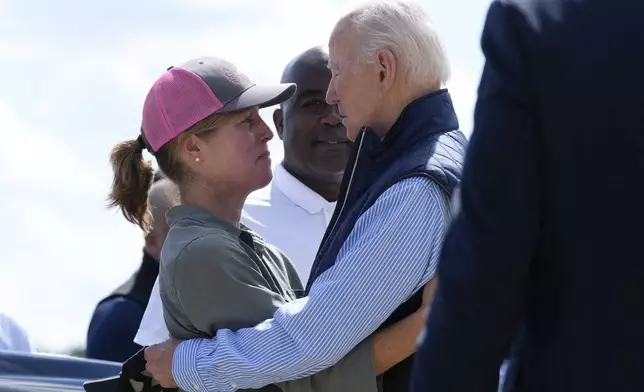 President Joe Biden talks with Asheville Mayor Esther Manheimer, as he arrives at Greenville-Spartanburg International Airport in Greer, S.C., Wednesday, Oct. 2, 2024, to survey damage from Hurricane Helene. (AP Photo/Susan Walsh)