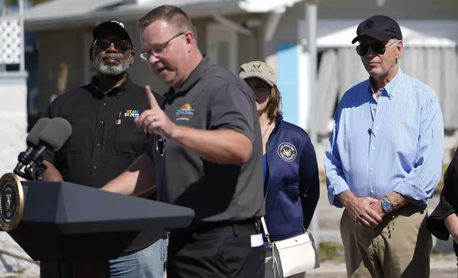 St. Pete Beach, Fla. Mayor Adrian Petrila speaks as President Joe Biden, right, listens Biden's visit to areas affected by Hurricane Milton in St. Pete Beach, Sunday, Oct. 13, 2024. (AP Photo/Manuel Balce Ceneta)