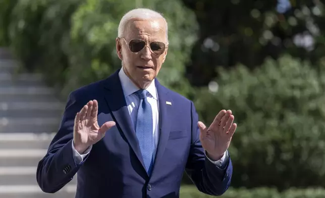 President Joe Biden gestures to the media as he walks to Marine One on the South Lawn of the White House in Washington, Saturday, Oct. 5, 2024. (AP Photo/Ben Curtis)