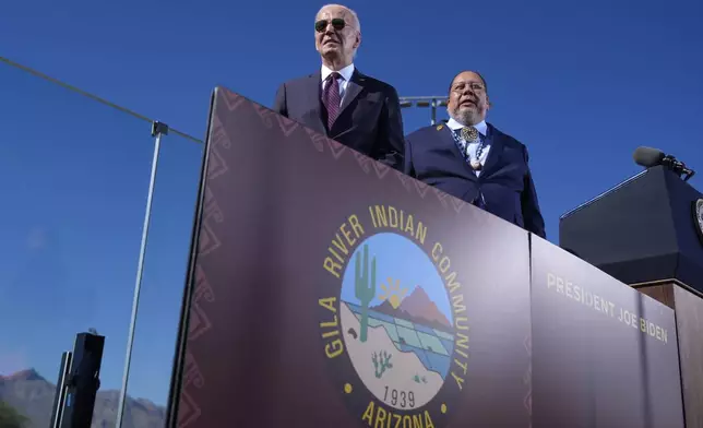 President Joe Biden, left, joined by Stephen Roe Lewis, Governor of the Gila River Indian Community, arrives to speak at the Gila Crossing Community School in the Gila River Indian Community reservation in Laveen, Ariz., Friday, Oct. 25, 2024. (AP Photo/Manuel Balce Ceneta)