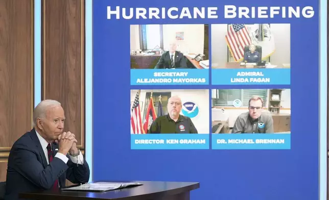 President Joe Biden, joined virtually by Vice President Kamala Harris and by Elizabeth Sherwood-Randall, Homeland Security Advisor to the President, not shown, listens to a briefing about preparations for Hurricane Milton and the response to Hurricane Helene in the South Court Auditorium on the White House complex in Washington, Wednesday, Oct. 9, 2024. (AP Photo/Mark Schiefelbein)