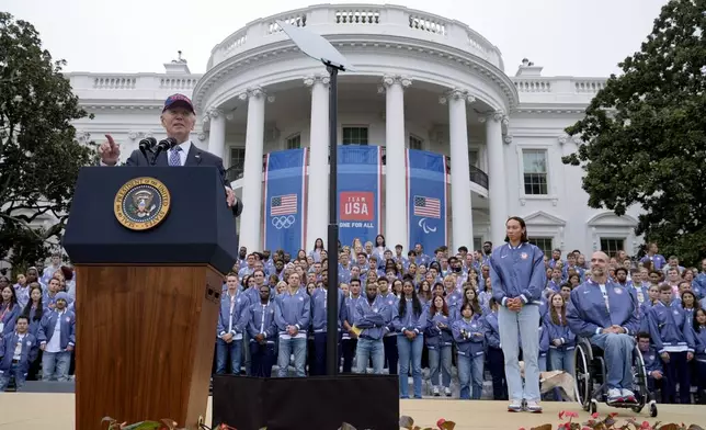 President Joe Biden, from left, speaks as Olympic swimmer Torri Huske and Paralympian basketball players Paul Schulte listen during at an event celebrating the 2024 U.S. Olympic and Paralympic teams on the South Lawn of the White House in Washington, Monday, Sept. 30, 2024. (AP Photo/Susan Walsh)