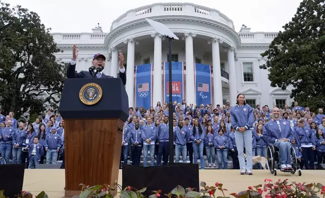 President Joe Biden, from left, speaks as Olympic swimmer Torri Huske and Paralympian basketball players Paul Schulte listen during at an event celebrating the 2024 U.S. Olympic and Paralympic teams on the South Lawn of the White House in Washington, Monday, Sept. 30, 2024. (AP Photo/Susan Walsh)