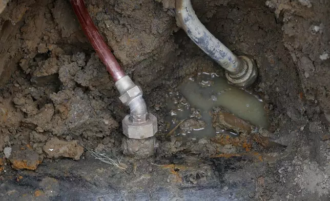 FILE - A copper water supply line, left, is shown connected to a water main after being installed for lead pipe, right, July 20, 2018, in Flint, Mich. (AP Photo/Paul Sancya, File)