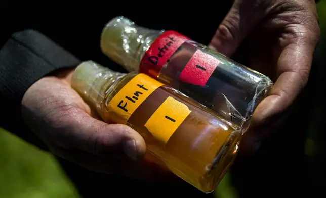 FILE - Virginia Tech professor Marc Edwards shows the difference in water quality between Detroit and Flint after testing, giving evidence after more than 270 samples were sent in from Flint that show high levels of lead during a news conference on Sept. 15, 2015, in downtown Flint, Mich. (Jake May/The Flint Journal via AP, File)