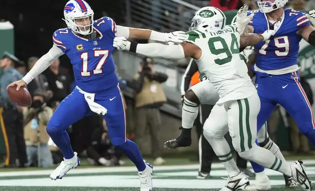 Buffalo Bills quarterback Josh Allen (17) scrambles away from New York Jets defensive end Solomon Thomas (94) during the first half of an NFL football game in East Rutherford, N.J., Monday, Oct. 14, 2024. (AP Photo/Pamela Smith)