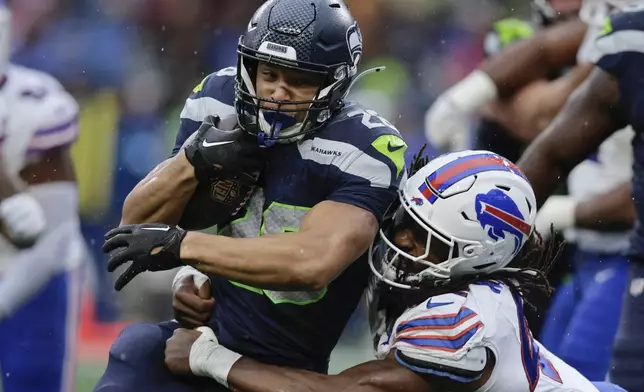 Seattle Seahawks running back Zach Charbonnet (26) carries the ball as Buffalo Bills running back Ray Davis (22) defends during the first half of an NFL football game, Sunday, Oct. 27, 2024, in Seattle. (AP Photo/John Froschauer)