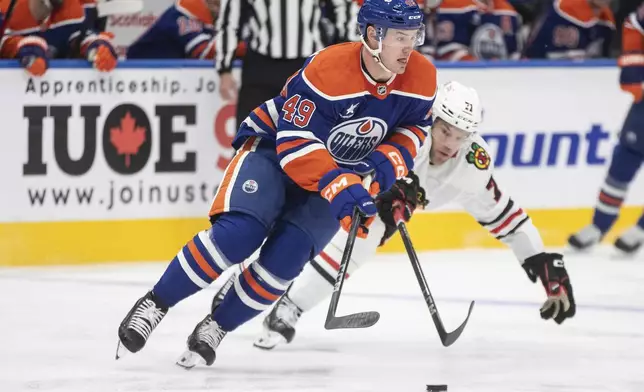 Chicago Blackhawks' Taylor Hall (71) tries to take the puck from Edmonton Oilers' Ty Emberson (49) during the first period of an NHL hockey game, Saturday, Oct. 12, 2024 in Edmonton, Alberta. (Jason Franson/The Canadian Press via AP)