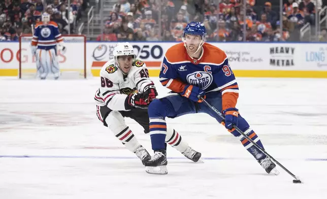 Chicago Blackhawks' Teuvo Teravainen (86) chases Edmonton Oilers' Connor McDavid (97) during the second period of an NHL hockey game in Edmonton, Alberta, Saturday, Oct. 12, 2024. (Jason Franson/The Canadian Press via AP)