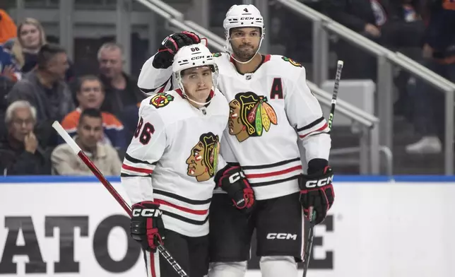 Chicago Blackhawks' Teuvo Teravainen (86) and Seth Jones (4) celebrate a goal against the Edmonton Oilers during third period NHL action in Edmonton on Saturday, October 12, 2024. (Jason Franson/The Canadian Press via AP)