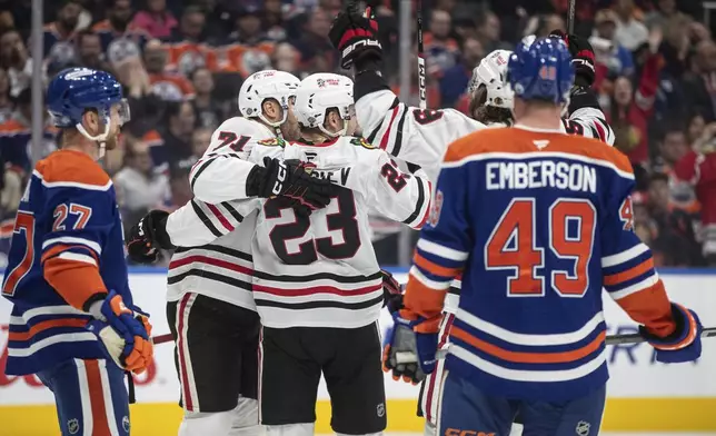 Chicago Blackhawks' Taylor Hall (71), Philipp Kurashev (23) and Tyler Bertuzzi (59) celebrate a goal against the Edmonton Oilers during the first period of an NHL hockey game, Saturday, Oct. 12, 2024 in Edmonton, Alberta. (Jason Franson/The Canadian Press via AP)