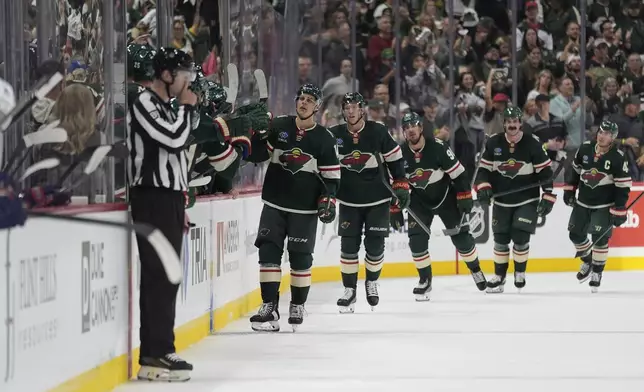 Minnesota Wild center Joel Eriksson Ek, front, celebrates with teammates after scoring during the second period of an NHL hockey game against the Columbus Blue Jackets, Thursday, Oct. 10, 2024, in St. Paul, Minn. (AP Photo/Abbie Parr)