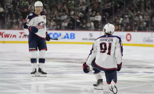 Columbus Blue Jackets center Kent Johnson (91) celebrates toward teammate defenseman Damon Severson, left, after scoring during the second period of an NHL hockey game against the Minnesota Wild, Thursday, Oct. 10, 2024, in St. Paul, Minn. (AP Photo/Abbie Parr)