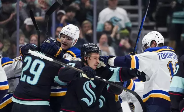 Seattle Kraken defenseman Vince Dunn (29) fights with St. Louis Blues defenseman Colton Parayko, left facing, as Kraken center Yanni Gourde, center, fights with Blues right wing Alexey Toropchenko (13) during the second period of an NHL hockey game Tuesday, Oct. 8, 2024, in Seattle. (AP Photo/Lindsey Wasson)