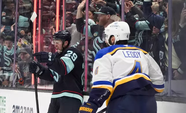 Seattle Kraken defenseman Vince Dunn reacts to scoring as St. Louis Blues defenseman Nick Leddy (4) looks on during the second period of an NHL hockey game Tuesday, Oct. 8, 2024, in Seattle. (AP Photo/Lindsey Wasson)