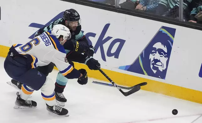 St. Louis Blues defenseman Philip Broberg (6) and Seattle Kraken right wing Oliver Bjorkstrand (22) vie for the puck during the first period of an NHL hockey game Tuesday, Oct. 8, 2024, in Seattle. (AP Photo/Lindsey Wasson)