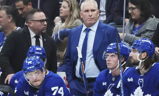 Toronto Maple Leafs head coach Craig Berube, center top, stands on the bench during third-period NHL hockey game action against the St. Louis Blues in Toronto, Thursday, Oct. 24, 2024. (Nathan Denette/The Canadian Press via AP)