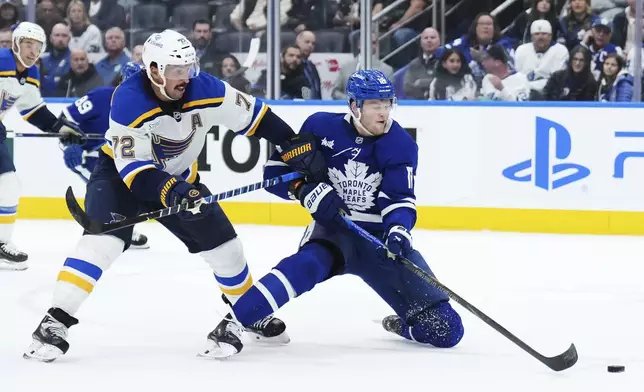 St. Louis Blues defenseman Justin Faulk (72) checks Toronto Maple Leafs forward Steven Lorentz (18) during second-period NHL hockey game action in Toronto, Thursday, Oct. 24, 2024. (Nathan Denette/The Canadian Press via AP)