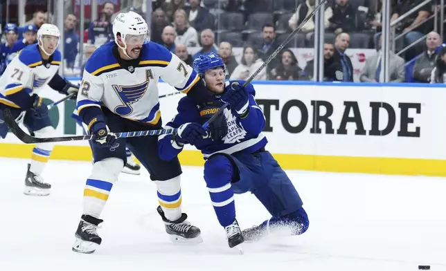 St. Louis Blues defenseman Justin Faulk (72) checks Toronto Maple Leafs forward Steven Lorentz (18) during second-period NHL hockey game action in Toronto, Thursday, Oct. 24, 2024. (Nathan Denette/The Canadian Press via AP)