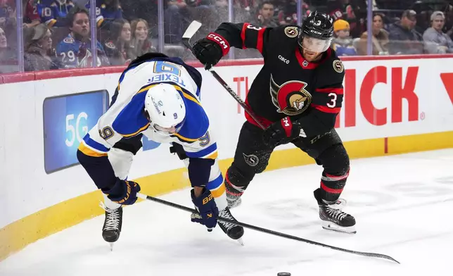 St. Louis Blues center Alexandre Texier (9) gets pushed off the puck by Ottawa Senators defenseman Nick Jensen (3) during the first period of an NHL hockey game in Ottawa, Ontario, Tuesday, Oct. 29, 2024. (Sean Kilpatrick/The Canadian Press via AP)