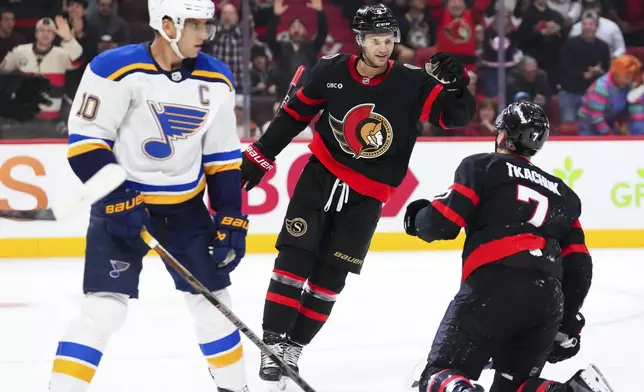 Ottawa Senators centre Josh Norris (9) congratulates teammate Brady Tkachuk (7) on his goal as St. Louis Blues centre Brayden Schenn (10) skates past during the second period of an NHL hockey game in Ottawa, Ontario, Tuesday, Oct. 29, 2024. (Sean Kilpatrick/The Canadian Press via AP)