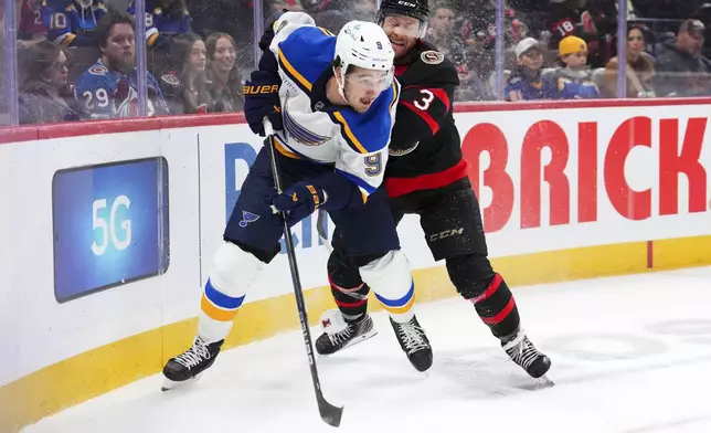 St. Louis Blues center Alexandre Texier (9) looks to make a pass as Ottawa Senators defenseman Nick Jensen (3) tries to push him off the puck during the first period of an NHL hockey game in Ottawa, Ontario, Tuesday, Oct. 29, 2024. (Sean Kilpatrick/The Canadian Press via AP)