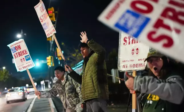 Boeing employees, including assembler Tyrone Hipolito, center, work the picket line after union members voted to reject a new contract offer from the company, Wednesday, Oct. 23, 2024, in Renton, Wash. (AP Photo/Lindsey Wasson)