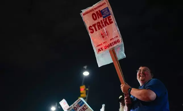 Machinist AJ Nelson, who has worked for Boeing for six years, works the picket line after union members voted to reject a new contract offer from the company, Wednesday, Oct. 23, 2024, in Renton, Wash. (AP Photo/Lindsey Wasson)