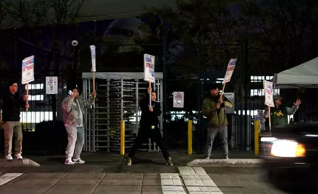 Boeing employees cheer and wave picket signs as a driver honks in support after a majority of union members voted to reject a new contract offer from the company, Wednesday, Oct. 23, 2024, in Renton, Wash. (AP Photo/Lindsey Wasson)