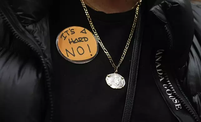 Boeing employee Gina Forbush wears an pin saying "IT'S A HARD NO!" while listening to the announcement that union members voted to reject a new contract offer from the company, Wednesday, Oct. 23, 2024, at Seattle Union Hall in Seattle. (AP Photo/Lindsey Wasson)