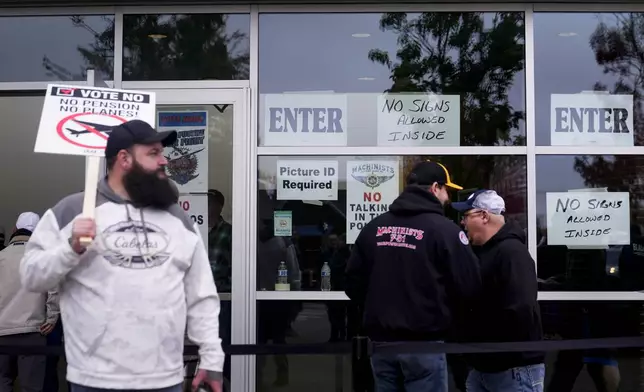 Boeing employees on strike enter a voting location to cast their ballots on a new contract offer from the company, Wednesday, Oct. 23, 2024, at the Angel of the Winds Arena in Everett, Wash. (AP Photo/Lindsey Wasson)