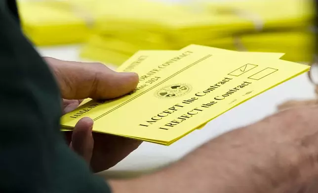 A volunteer holds a vote to accept a new contract offer from Boeing, Wednesday, Oct. 23, 2024, at Seattle Union Hall in Seattle. (AP Photo/Lindsey Wasson)